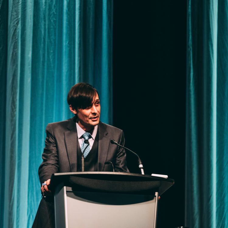 Pierre Asselin at the podium at We Believe 2019.