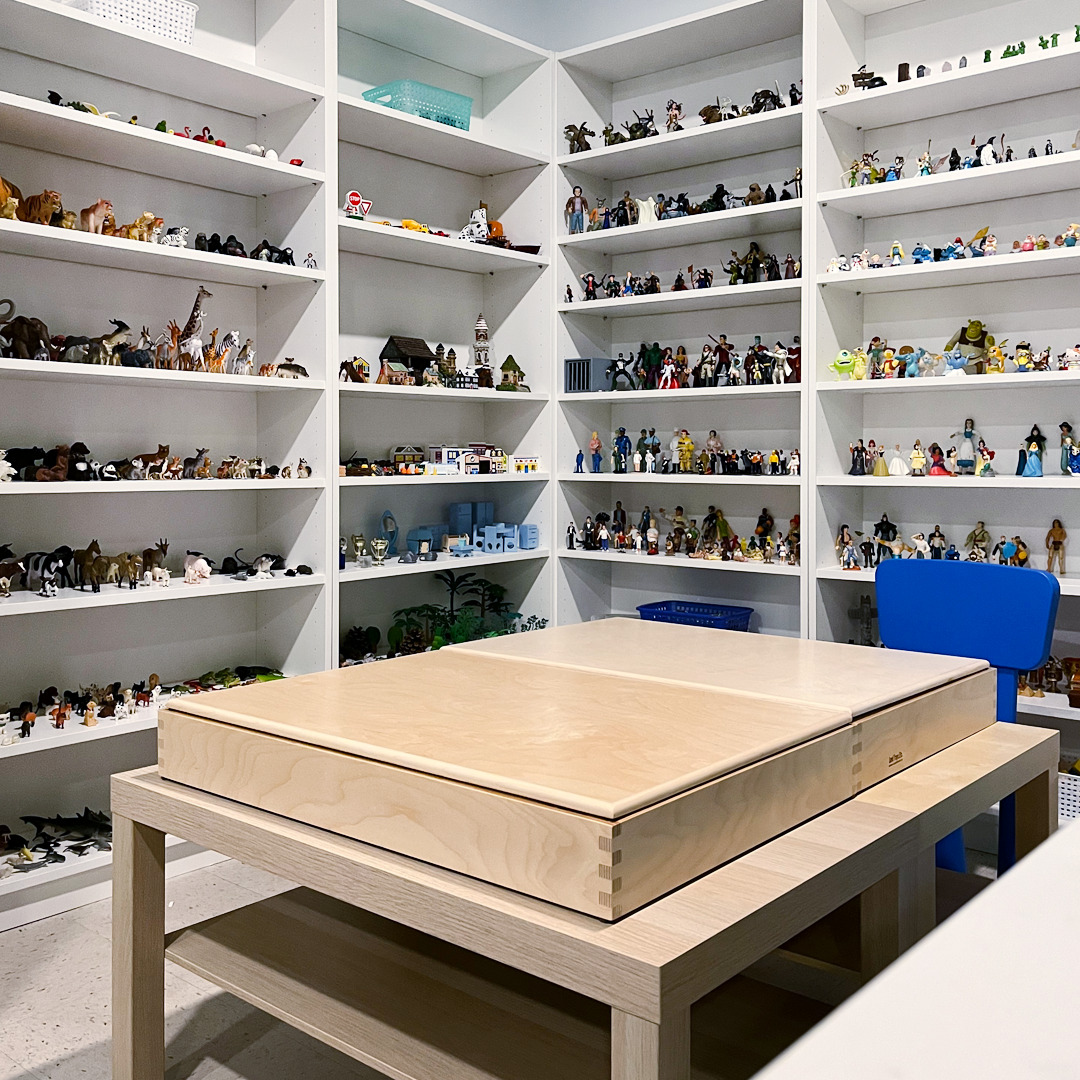 A photo of the child and youth counselling playroom shows a sand tray and shelves full of figurines used for therapeutic play