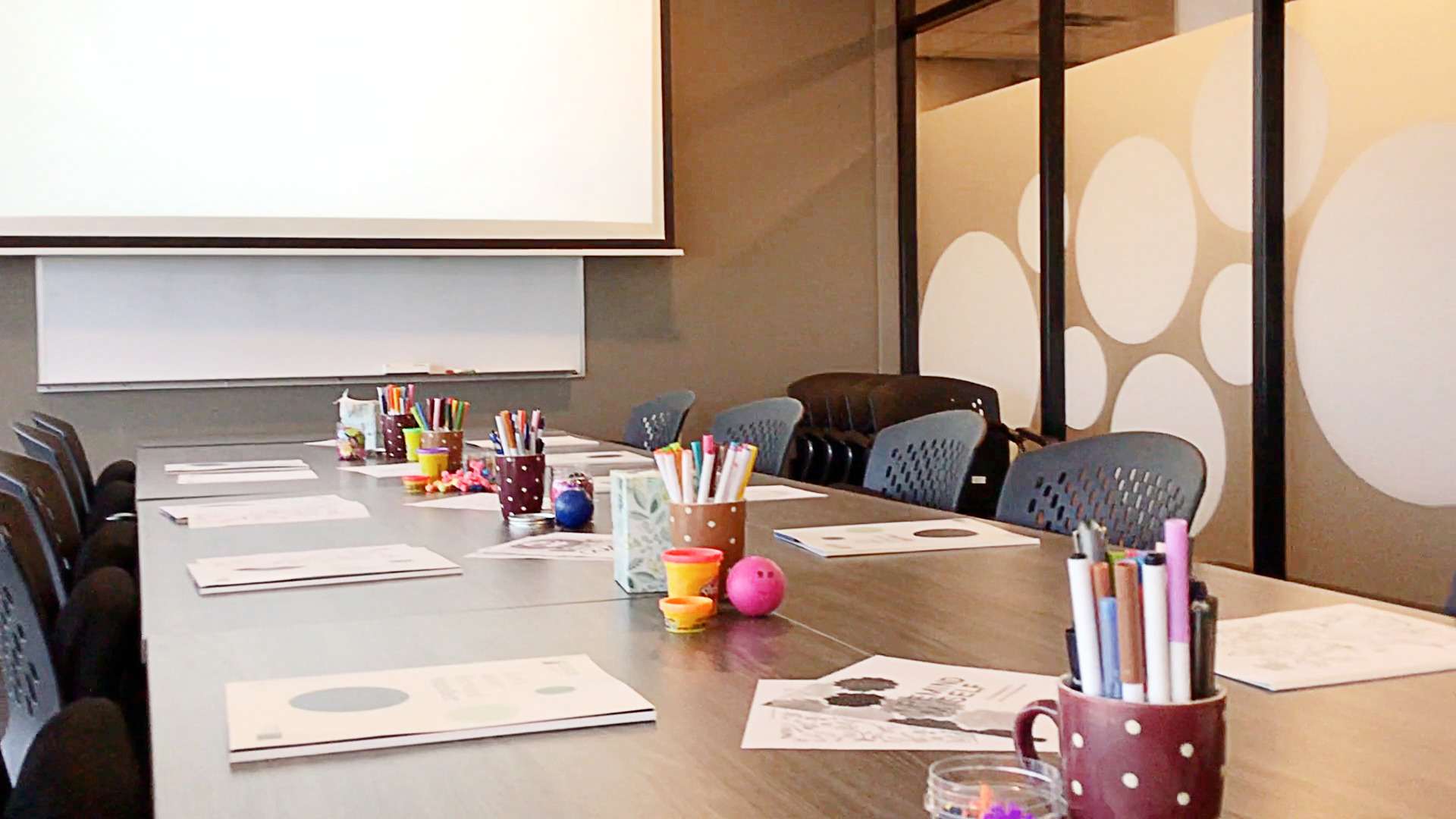 SACE services being offered in the boardroom, with workbooks and fidget toys arranged on the long table for participants