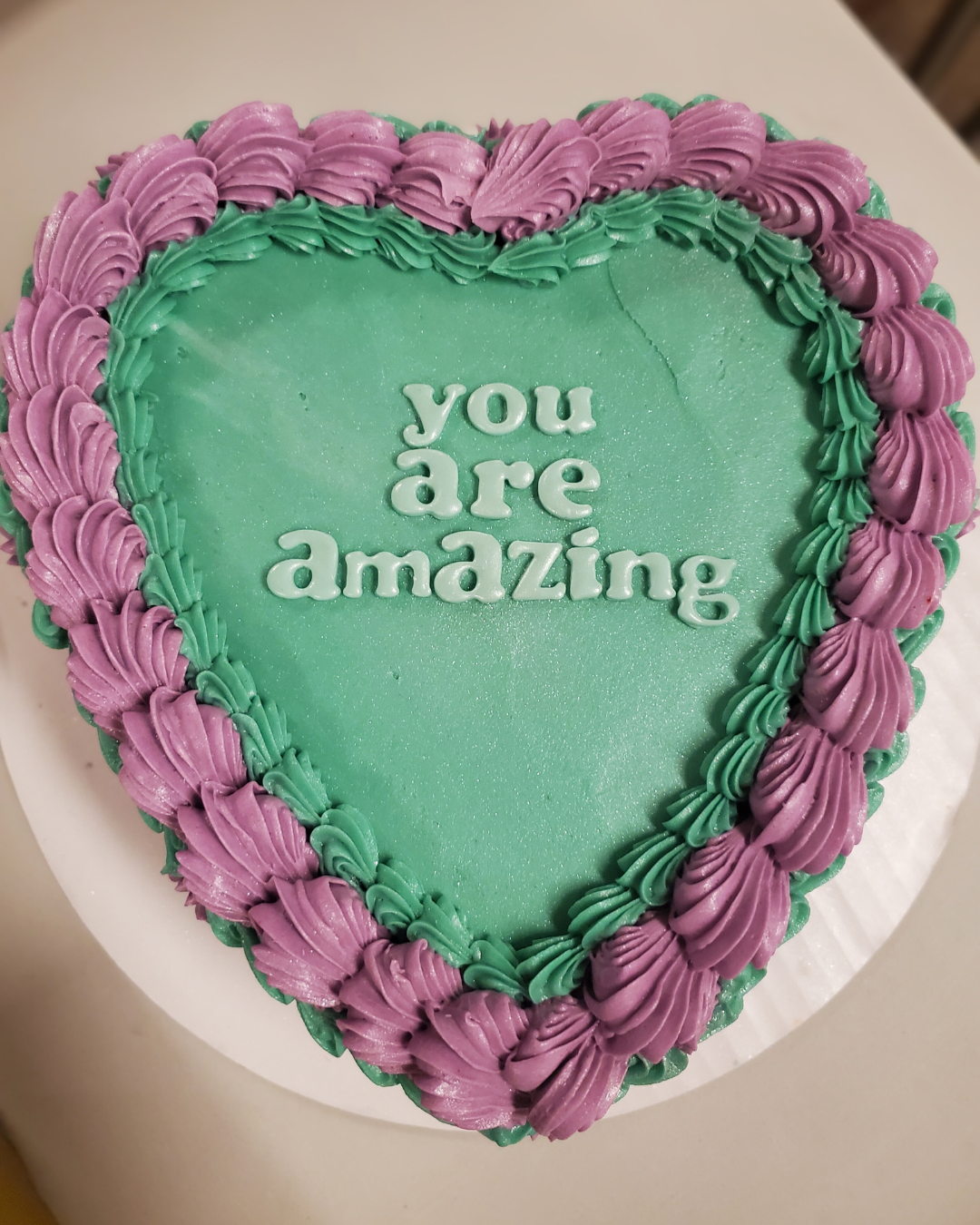 A teal and magenta cake with "You Are Amazing" written on it, intended to show appreciation to the SACE volunteers.